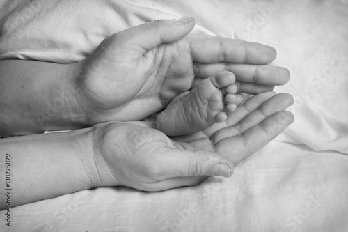 Zdjęcie XXL Stopa dziecka w rękach matki