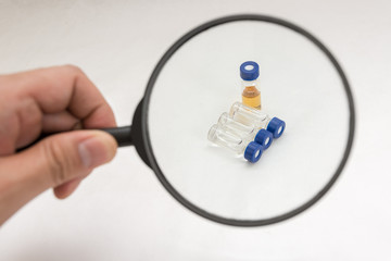 Handing magnify glass on sample vial