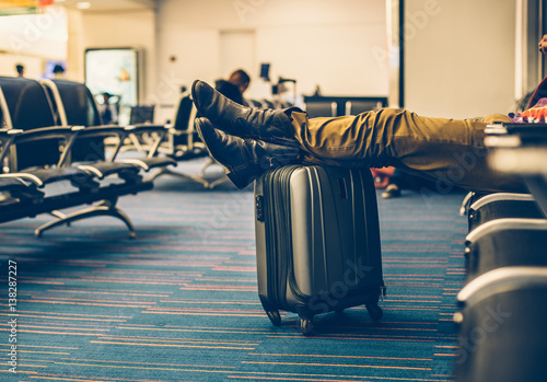 Plakat Pasażer wraz z bagażem oczekującym na lot opóźniający na postoju na lotnisku i relaksujący.