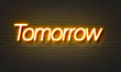 Tomorrow neon sign on brick wall background.