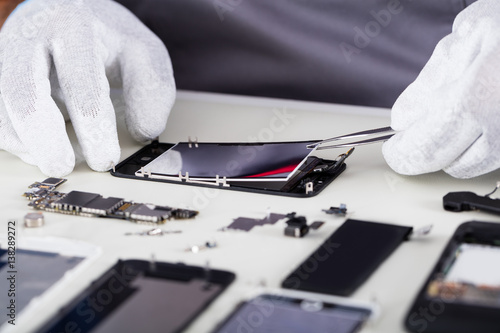 Fotomural Repairman Disassembling Smartphone With Tweezers
