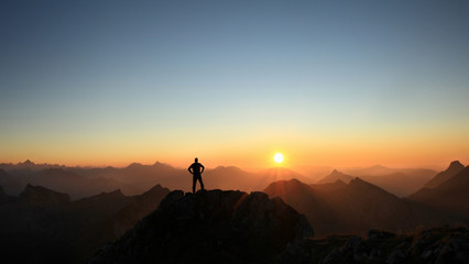 Poster - Man reaching summit enjoying freedom and looking towards mountains sunset.
