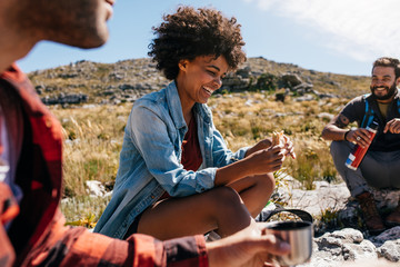 Wall Mural - Woman with friends taking a break during hike