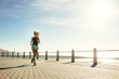 © Jacob Lund - Healthy woman running on the sea side promenade