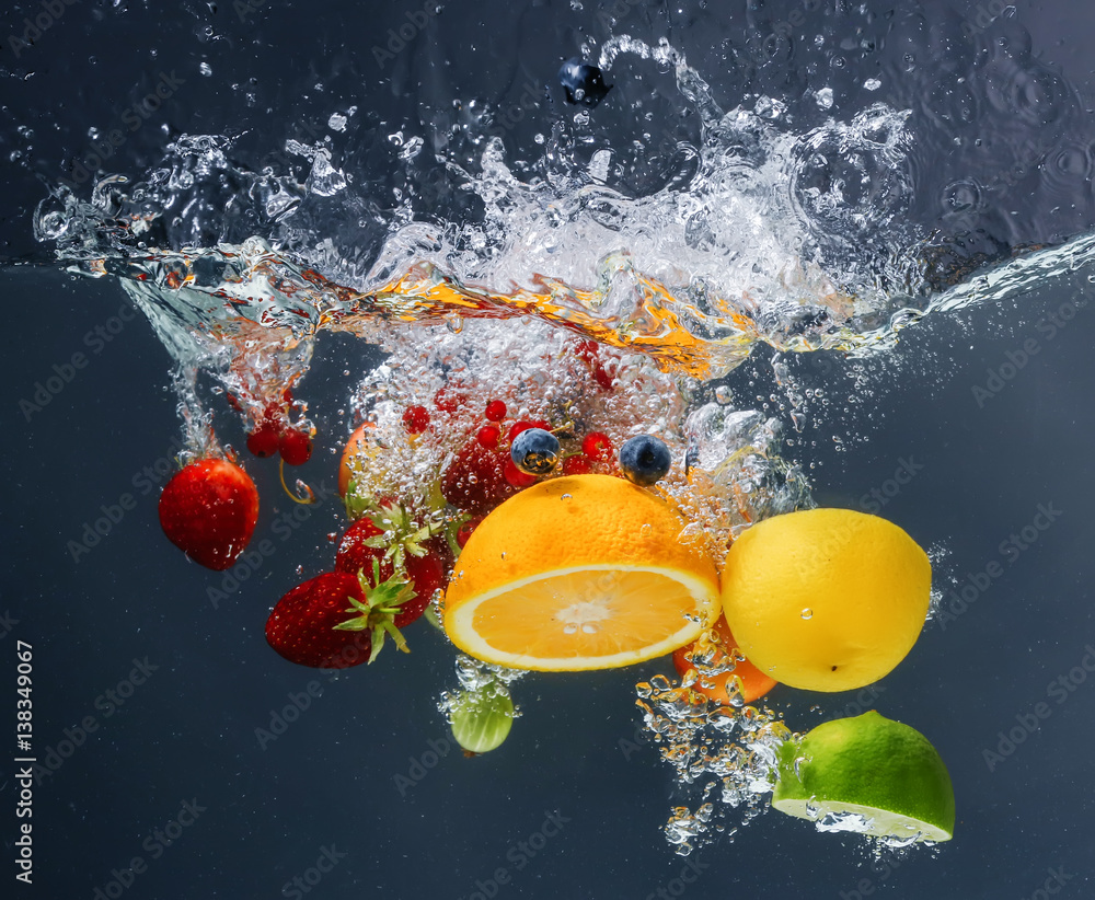 Different fruits and berries falling in water on dark background - obrazy, fototapety, plakaty 
