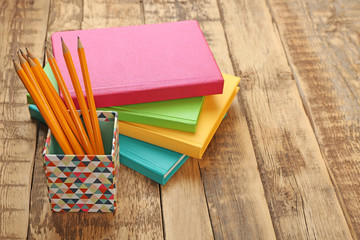 Sticker - Colorful notebooks on wooden background