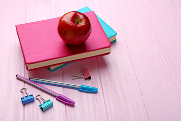 Sticker - Books and apple on wooden background