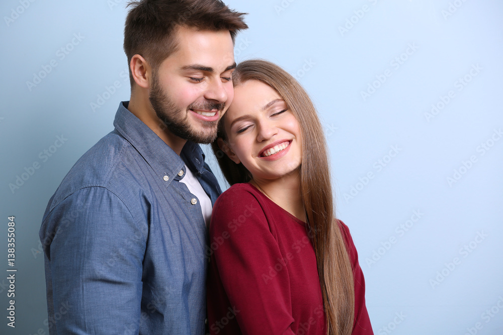 Cute young couple on color background