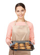 © Africa Studio - Young woman in apron holding baking tray with cookies on white background