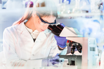 Fototapete - Life science female researcher microscoping in scientific genetic laboratory. Healthcare and biotechnology.