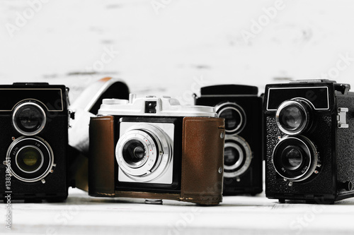Stampe collection old vintage retro photo cameras on white wooden background