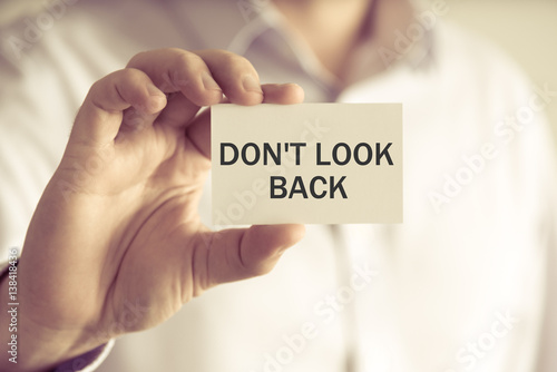 Foto Businessman holding DO NOT LOOK BACK message card