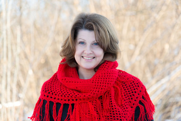 Wall Mural - Beautiful woman with red knitted shawl on shoulders of the outside