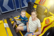 © Brocreative - Family enjoying a day at the amusement park. Sitting in an automobile theme park ride ready to go on a warm summer day outdoors. Smiling and having fun together as a family