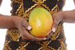 mains femme noire tenant une mangue