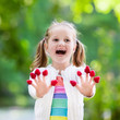 © famveldman - Child picking and eating raspberry in summer