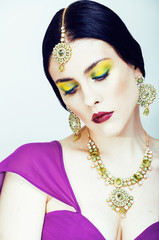 young pretty caucasian woman like indian in ethnic jewelry close up on white, bridal bright makeup