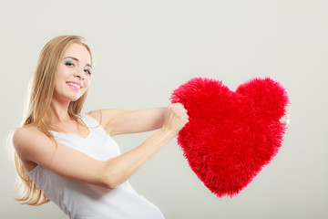 woman holding heart shaped pillow love symbol