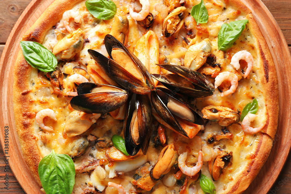Delicious seafood pizza on wooden background