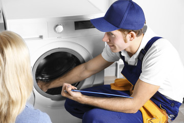 Wall Mural - Plumber repairing washing machine