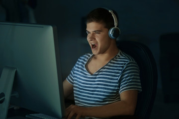 Canvas Print - Teenager playing computer game at home late in evening