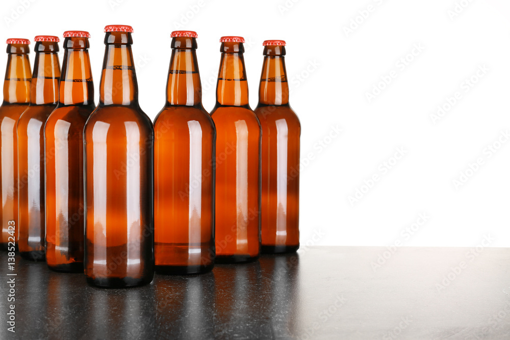 Bottles of beer on table against white background