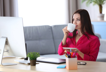 Canvas Print - Young beautiful designer drinking coffee in office