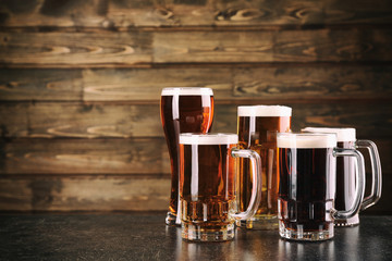 Wall Mural - Glasses with beer on wooden background