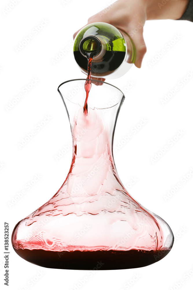 Pouring wine in carafe on white background