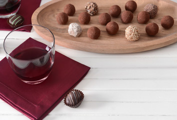 Sticker - Delicious chocolate truffles and red wine on light background