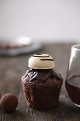 Canvas Print - Closeup of delicious chocolate cake with truffles and red wine on wooden table