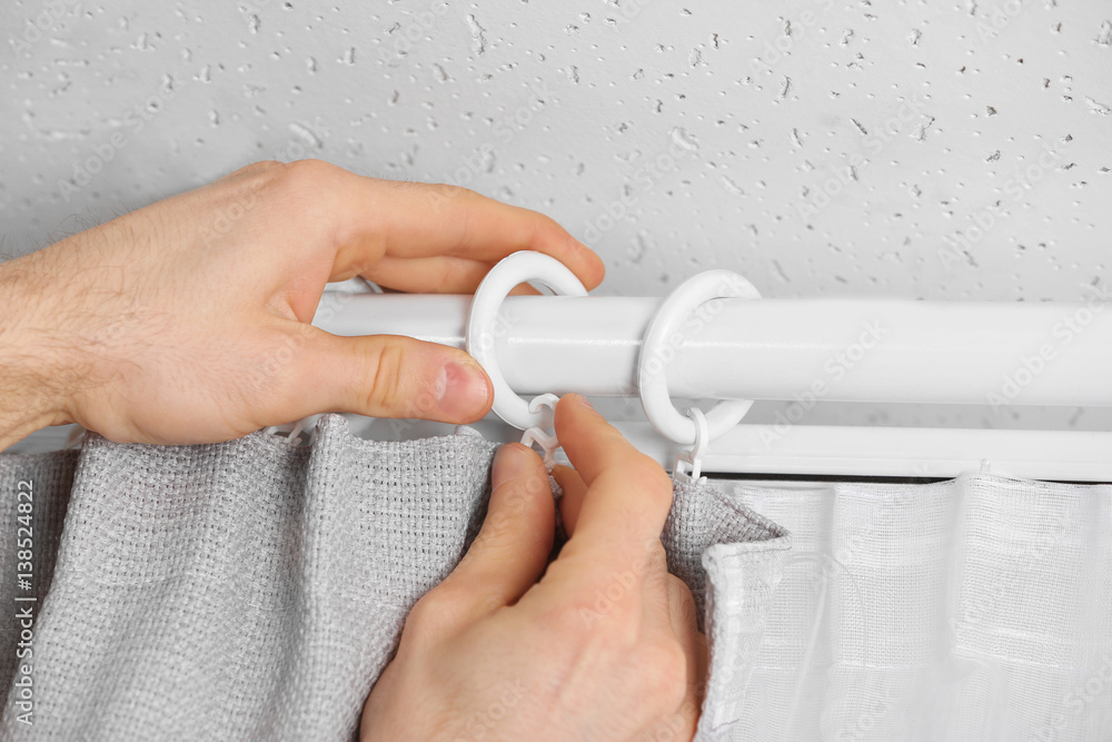 Male hands installing curtains over window Stock Photo | Adobe Stock
