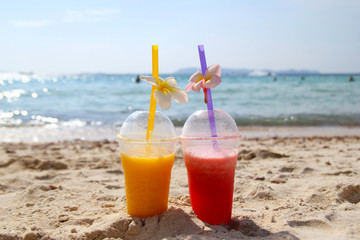 Travel to island Koh Larn, Thailand. Two glasses with mango juice and watermelon juice on the beach in the sunny summer weather.