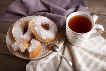 Wall Mural - Delicious homemade doughnuts and cup of tea on table