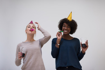 Wall Mural - smiling women in party caps blowing to whistles