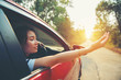 © stcom - Happy woman hand out window car red with sunlight