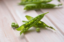 Split, Green Pea Pods And Peas On Pink, Wooden Board Close Up