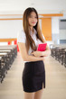 © tiniroma - Portrait of thai adult student university uniform beautiful girl reading red book