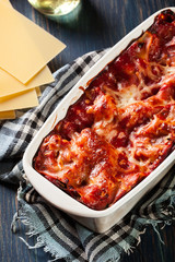 Wall Mural - Hot tasty lasagna with spinach in ceramic casserole dish