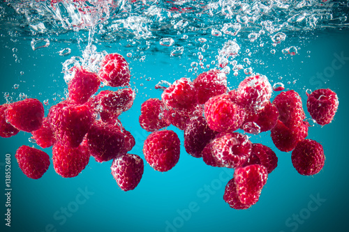 Fototapeta na wymiar Fresh raspberries dropped into water..