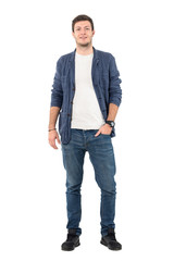 Wall Mural - Happy smiling man in jeans and denim shirt with hand in pocket looking at camera. Full body length portrait isolated over white background.