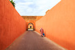 Muslim woman walking through a narrow street with gate in Marrakech