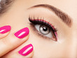 © Valua Vitaly - Closeup woman face with pink nails near eyes.