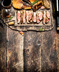 Wall Mural - Meat grill. Pieces of pork grilled with spices and red wine. On the old wooden table.