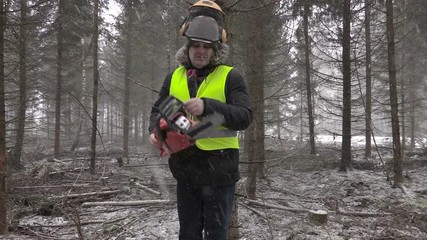 Wall Mural - Lumberjack with chainsaw in forest in snow storm