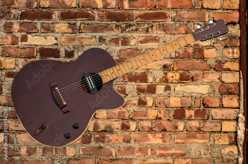 klasyczna-gitara-akustyczna-na-tle-ceglanej-sciany
