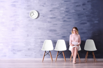 Wall Mural - Young woman waiting for job interview in reception hall