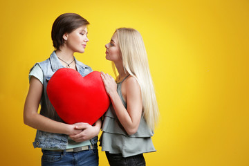 Sticker - Young lesbian couple with decorative heart on color background