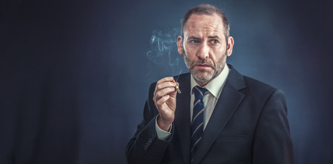 Mature Businessman smoking a cigarette