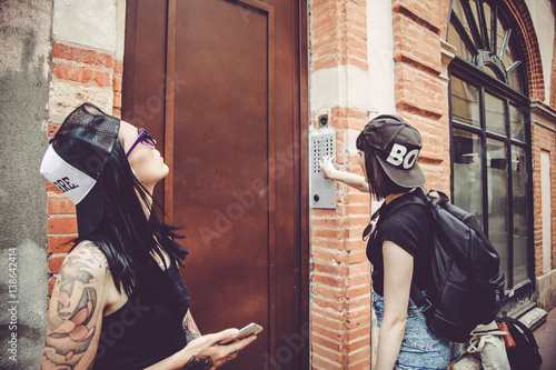 Fotografie, Obraz Attente de deux jeunes femmes devant la porte d'un immeuble
